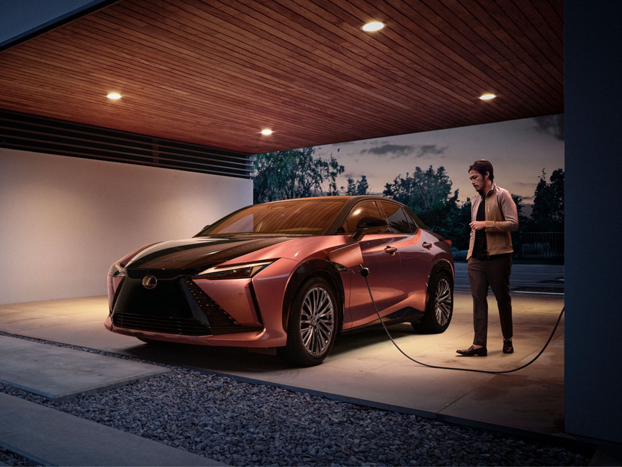 A man plugging aLexus RZ 450e into a home charging station 